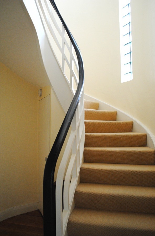 Идея дизайна: изогнутая лестница среднего размера в стиле ретро с ступенями с ковровым покрытием и ковровыми подступенками