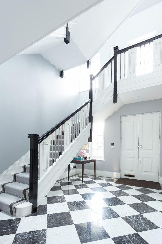 На фото: угловая лестница в классическом стиле с крашенными деревянными ступенями и крашенными деревянными подступенками