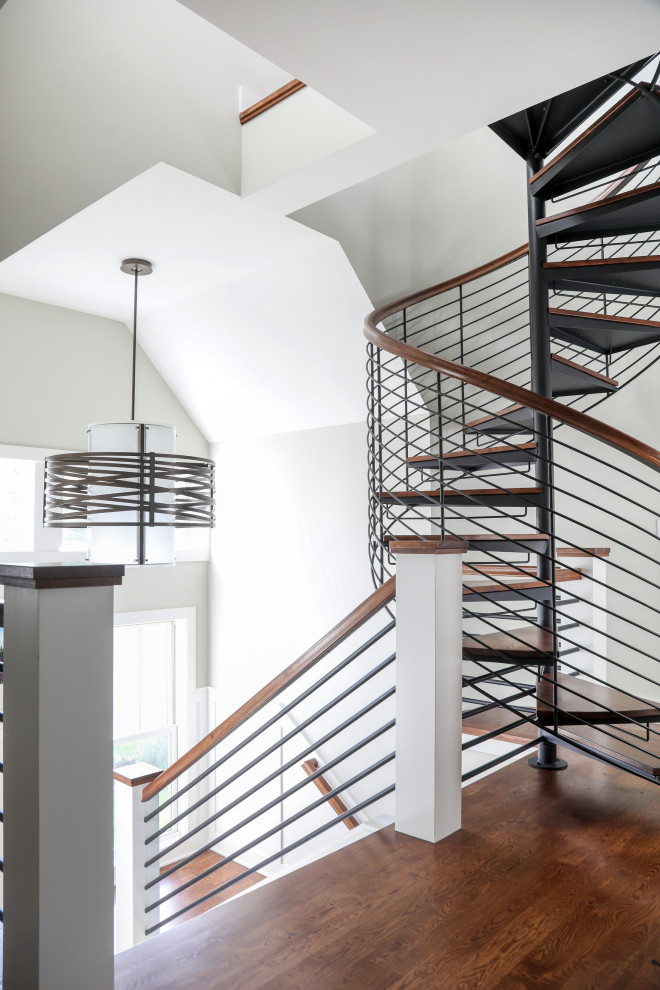 Ejemplo de escalera de caracol moderna pequeña sin contrahuella con escalones de madera y barandilla de metal