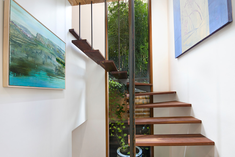 Свежая идея для дизайна: изогнутая лестница в стиле фьюжн с деревянными ступенями и металлическими перилами без подступенок - отличное фото интерьера