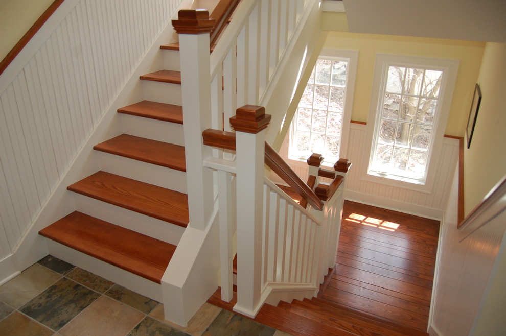 На фото: п-образная лестница среднего размера в классическом стиле с деревянными ступенями и крашенными деревянными подступенками с