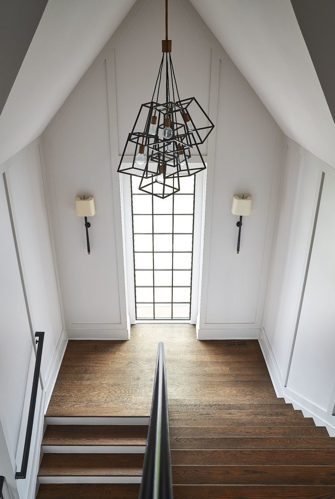 Foto de escalera contemporánea con escalones de madera, contrahuellas de madera pintada y barandilla de metal