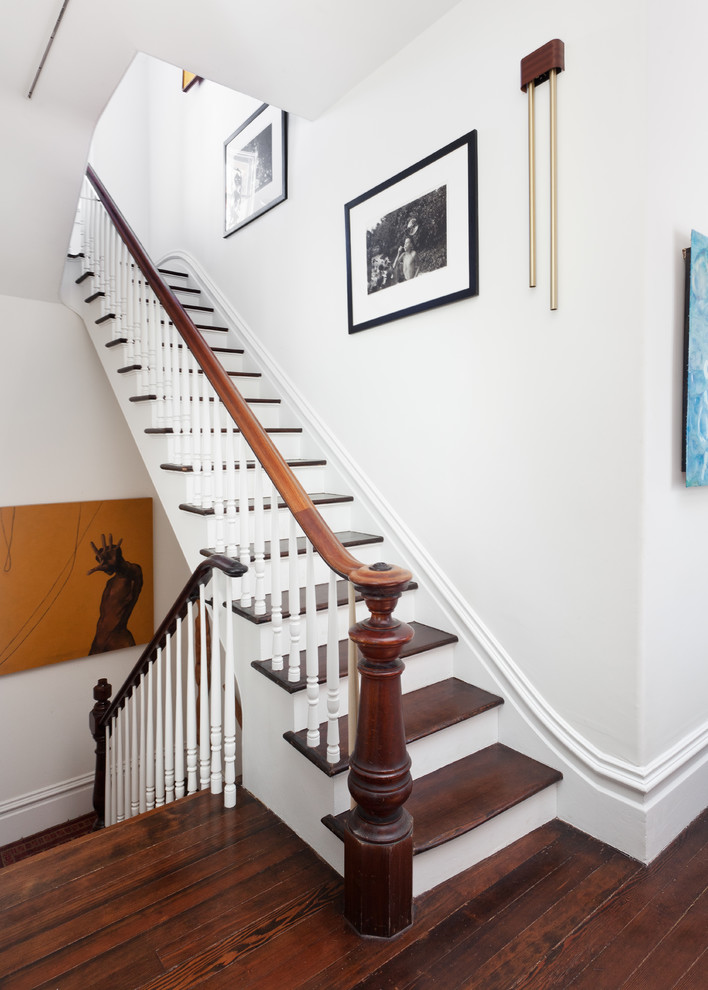 На фото: п-образная деревянная лестница среднего размера в викторианском стиле с деревянными ступенями и деревянными перилами с