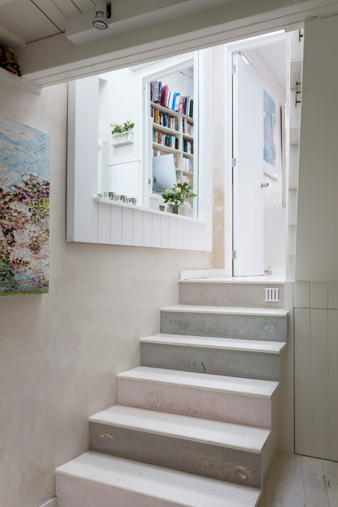 This is an example of a romantic painted wood straight staircase in London with painted wood risers.