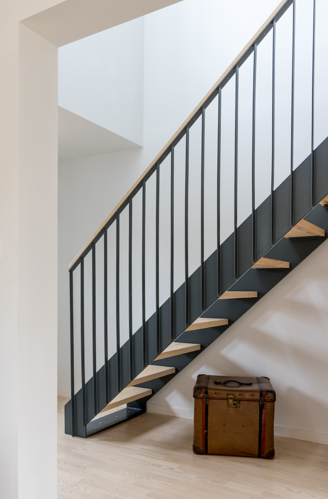 На фото: прямая лестница среднего размера в скандинавском стиле с деревянными ступенями и металлическими перилами без подступенок