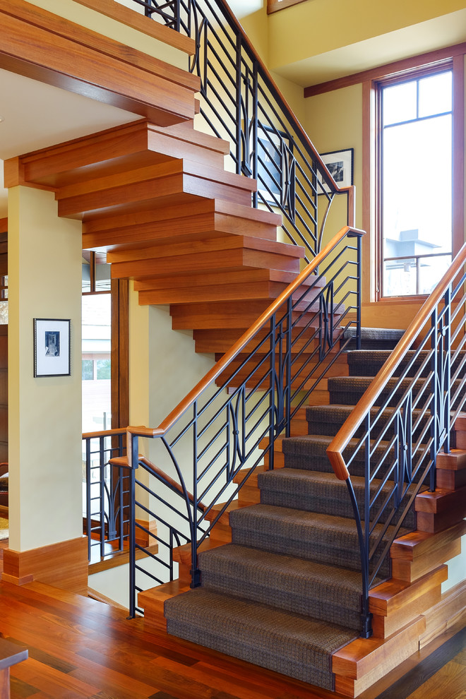 Diseño de escalera en U de estilo americano grande con escalones de madera y contrahuellas de madera
