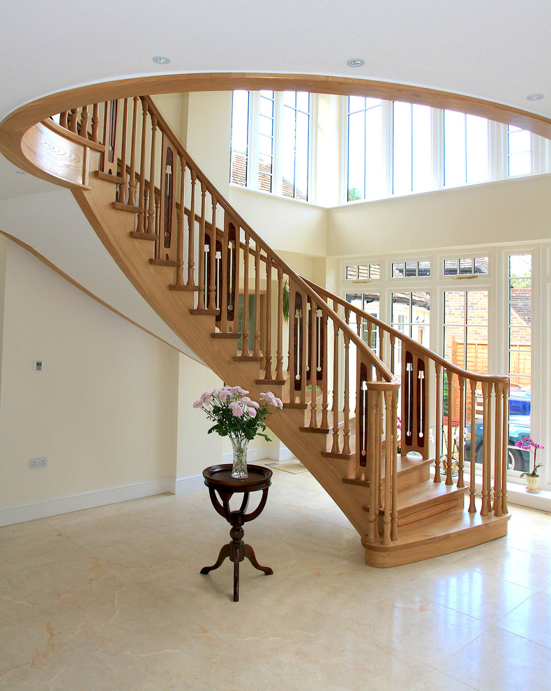 Réalisation d'un grand escalier courbe avec des marches en bois et des contremarches en bois.