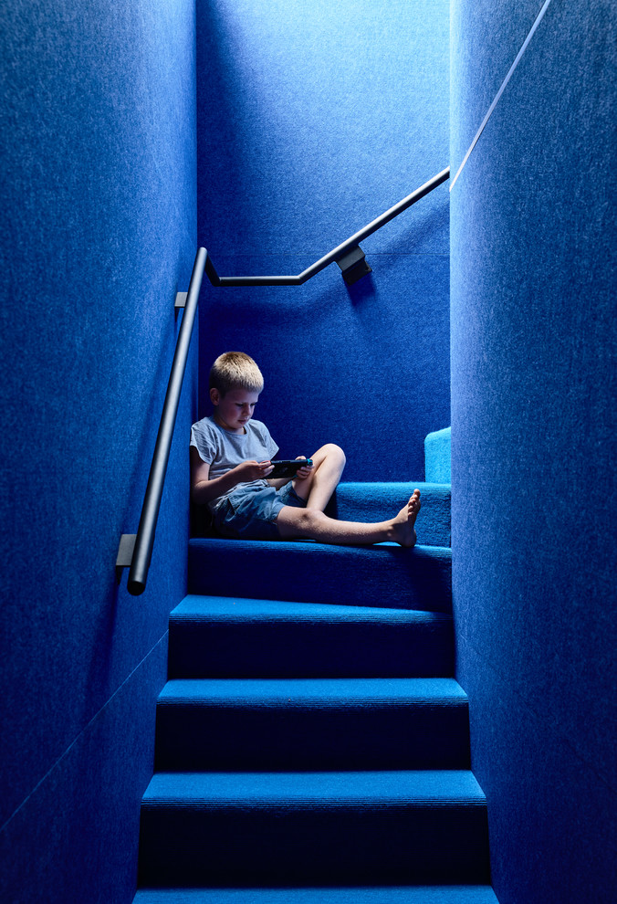 Kleine Moderne Treppe in L-Form mit Teppich-Treppenstufen, Teppich-Setzstufen und Stahlgeländer in Melbourne