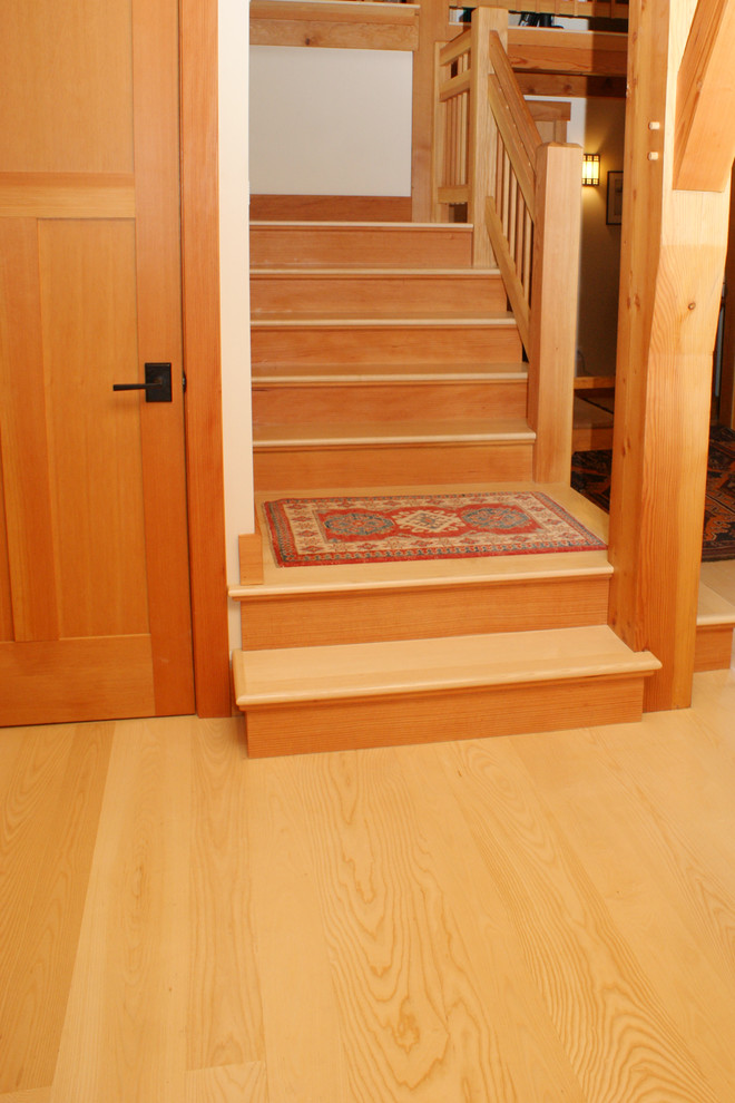На фото: угловая деревянная лестница среднего размера в стиле кантри с деревянными ступенями и деревянными перилами с
