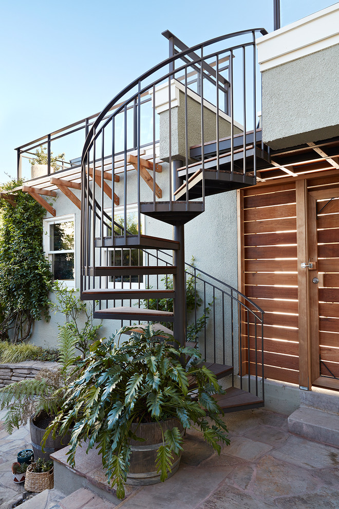 Aménagement d'un escalier sans contremarche hélicoïdal classique de taille moyenne avec des marches en bois et un garde-corps en métal.