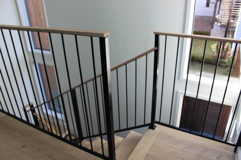 Staircase - small modern wooden u-shaped metal railing staircase idea in Austin with wooden risers