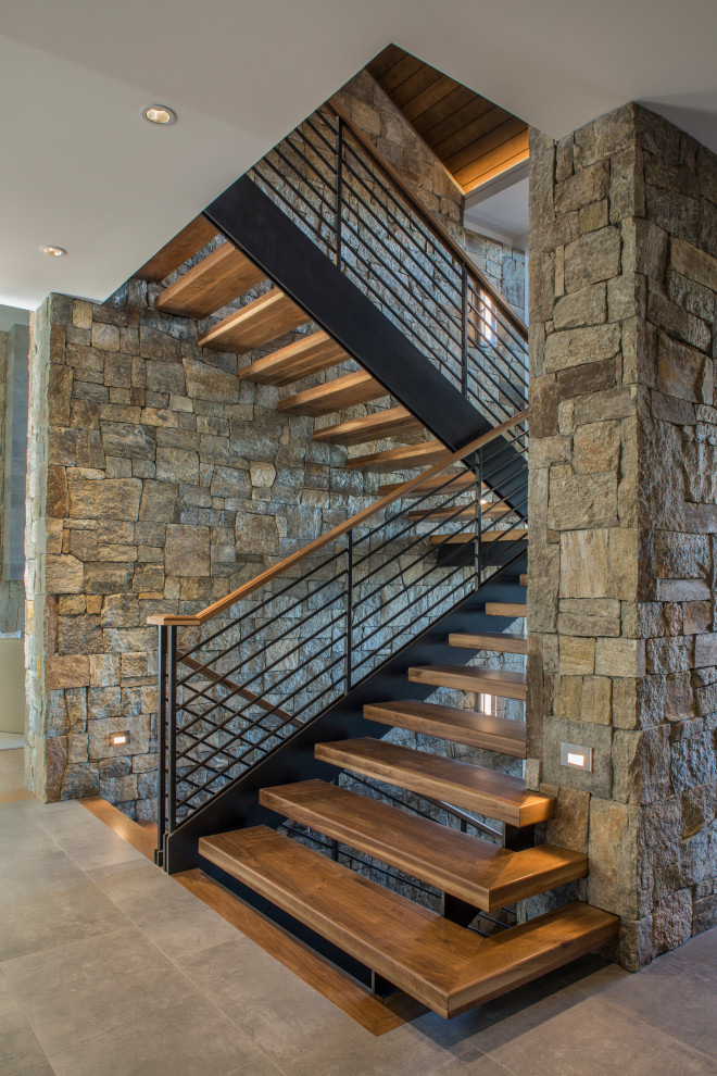 Imagen de escalera suspendida contemporánea sin contrahuella con escalones de madera y barandilla de cable