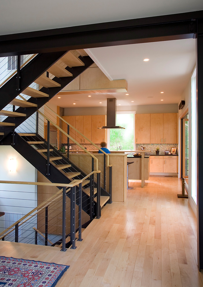 На фото: большая прямая металлическая лестница в стиле модернизм с деревянными ступенями с