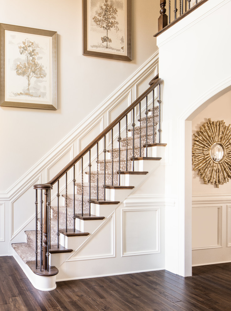 На фото: прямая лестница в стиле неоклассика (современная классика) с ступенями с ковровым покрытием, крашенными деревянными подступенками и перилами из смешанных материалов