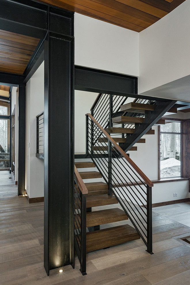 Стильный дизайн: деревянная лестница на больцах, среднего размера в современном стиле с деревянными ступенями и металлическими перилами - последний тренд