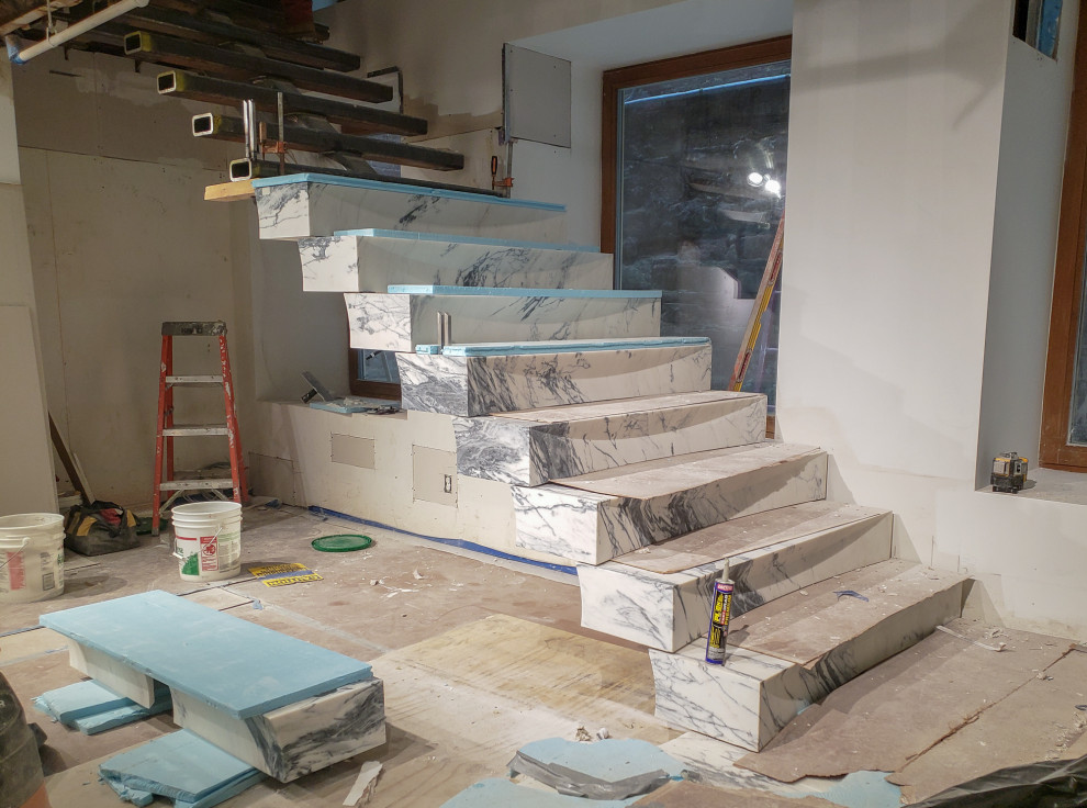 Example of a huge minimalist marble floating staircase design in New York with marble risers