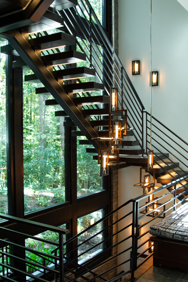 Свежая идея для дизайна: лестница на больцах в стиле модернизм с деревянными ступенями и металлическими перилами - отличное фото интерьера