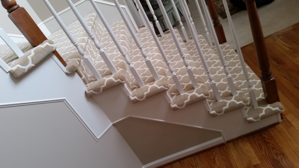 This is an example of a medium sized modern carpeted l-shaped staircase in Detroit with carpeted risers.