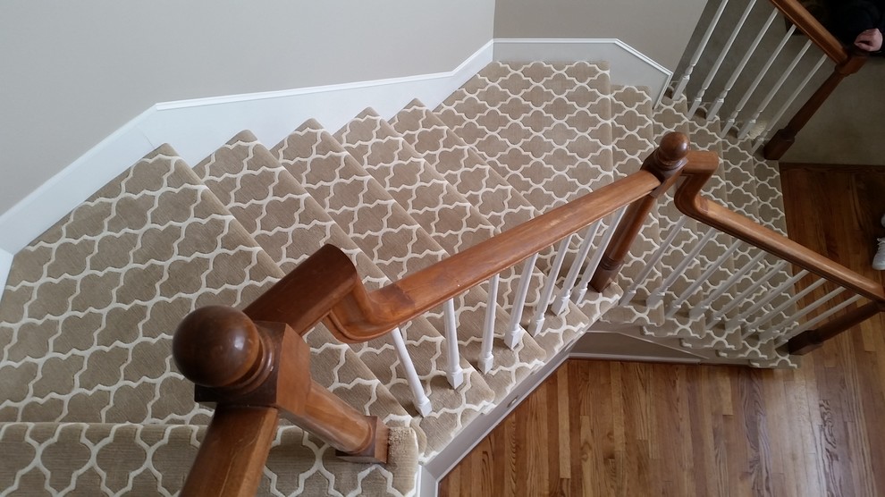 Photo of a medium sized modern carpeted l-shaped staircase in Detroit with carpeted risers.