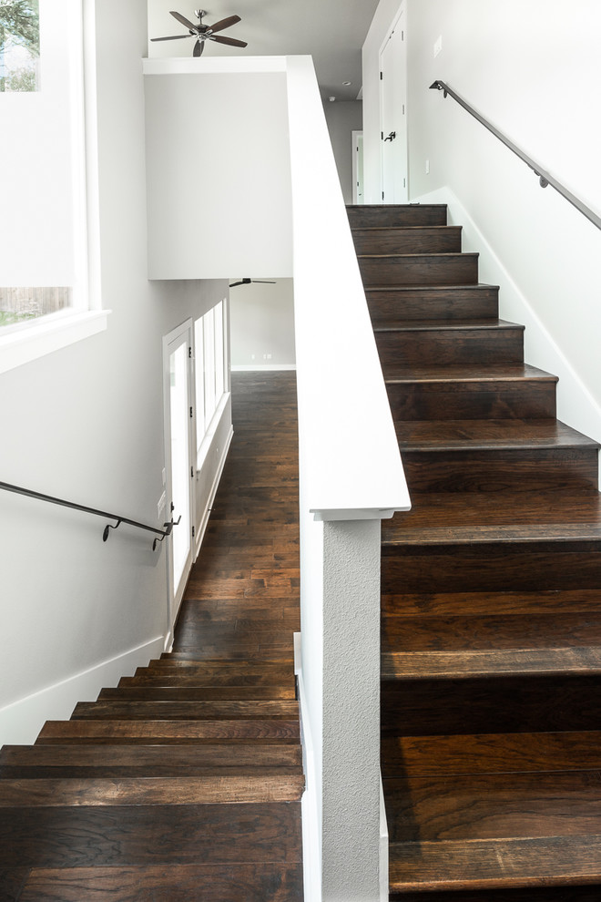 Contemporary wood straight staircase in Austin with wood risers.