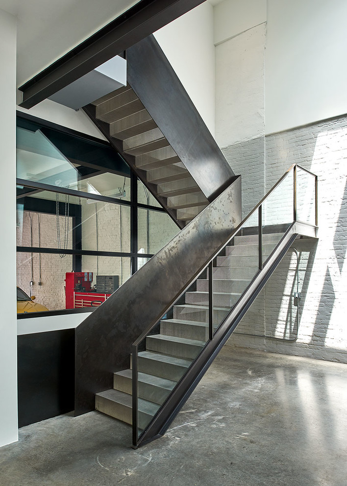 На фото: п-образная металлическая лестница в стиле лофт с металлическими ступенями и перилами из смешанных материалов с