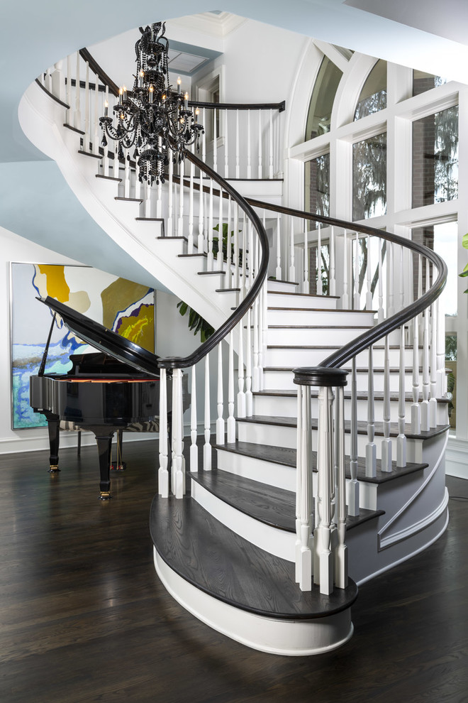 Idée de décoration pour un escalier peint courbe tradition avec des marches en bois et un garde-corps en bois.