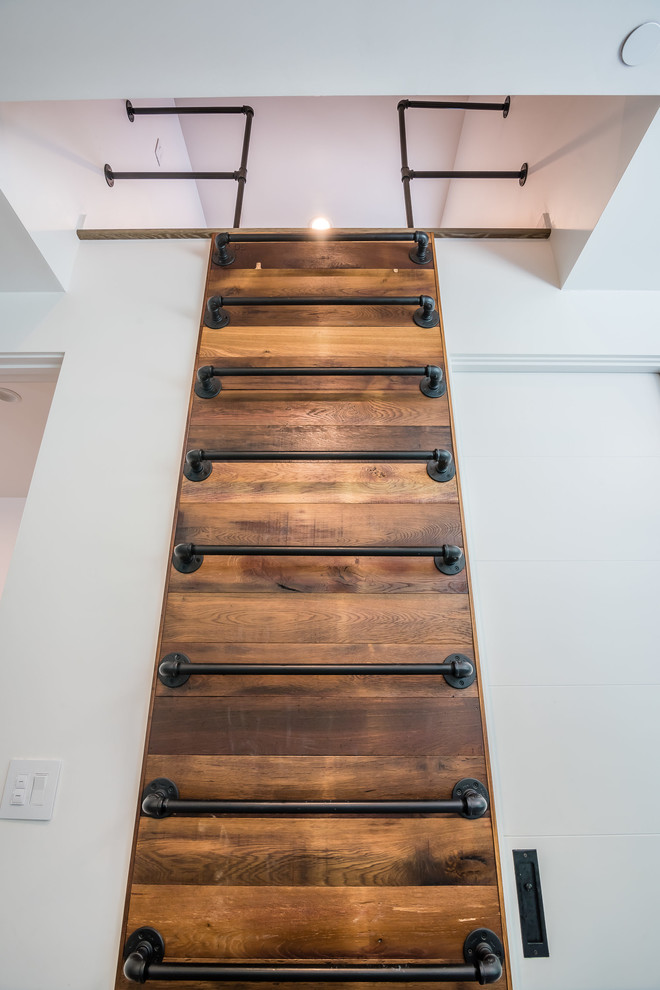 На фото: металлическая лестница в стиле кантри с металлическими ступенями и металлическими перилами с