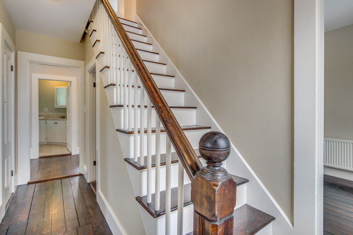 На фото: прямая лестница среднего размера в викторианском стиле с деревянными ступенями и крашенными деревянными подступенками с