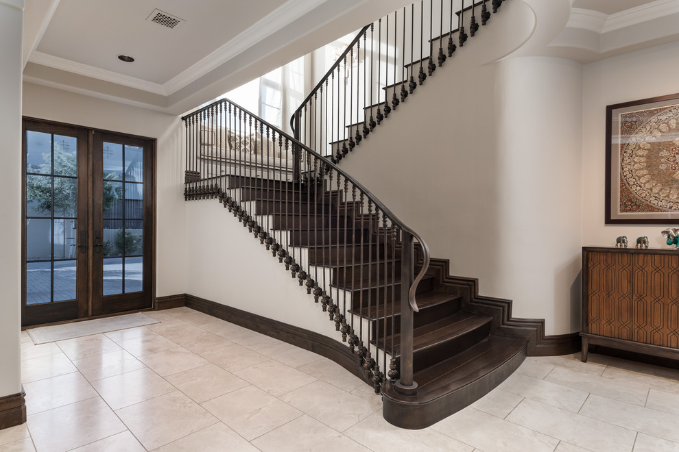 Imagen de escalera curva moderna extra grande con escalones de madera, contrahuellas de madera y barandilla de metal