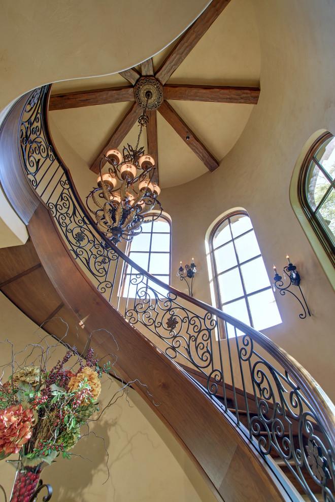 На фото: огромная деревянная лестница на больцах в классическом стиле с деревянными ступенями и перилами из смешанных материалов