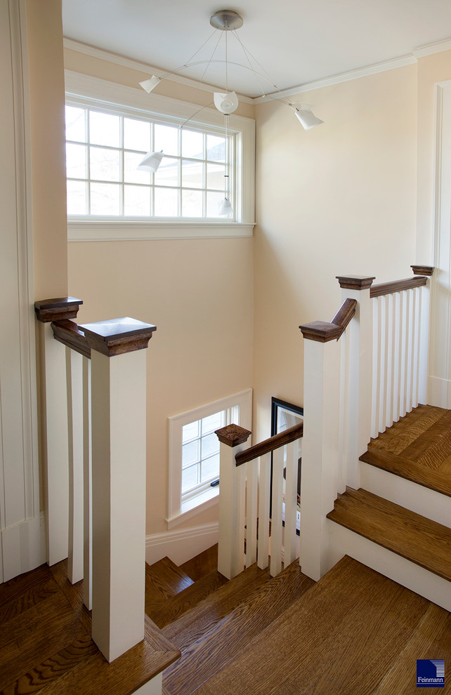 На фото: лестница в стиле неоклассика (современная классика) с деревянными ступенями и крашенными деревянными подступенками с