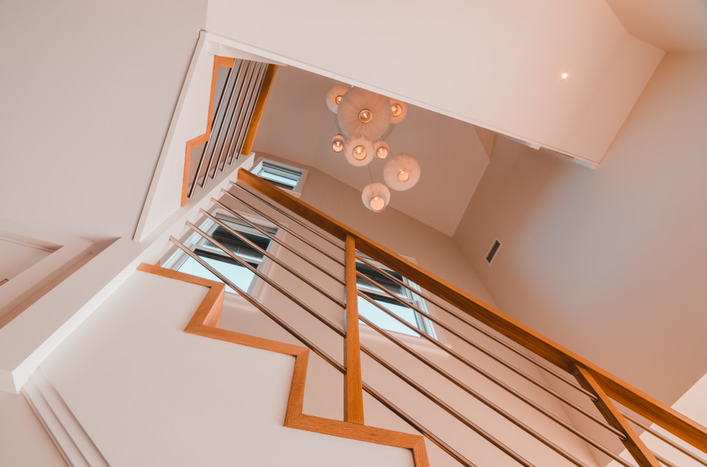 Foto de escalera curva minimalista de tamaño medio con escalones de madera, contrahuellas de madera y barandilla de madera