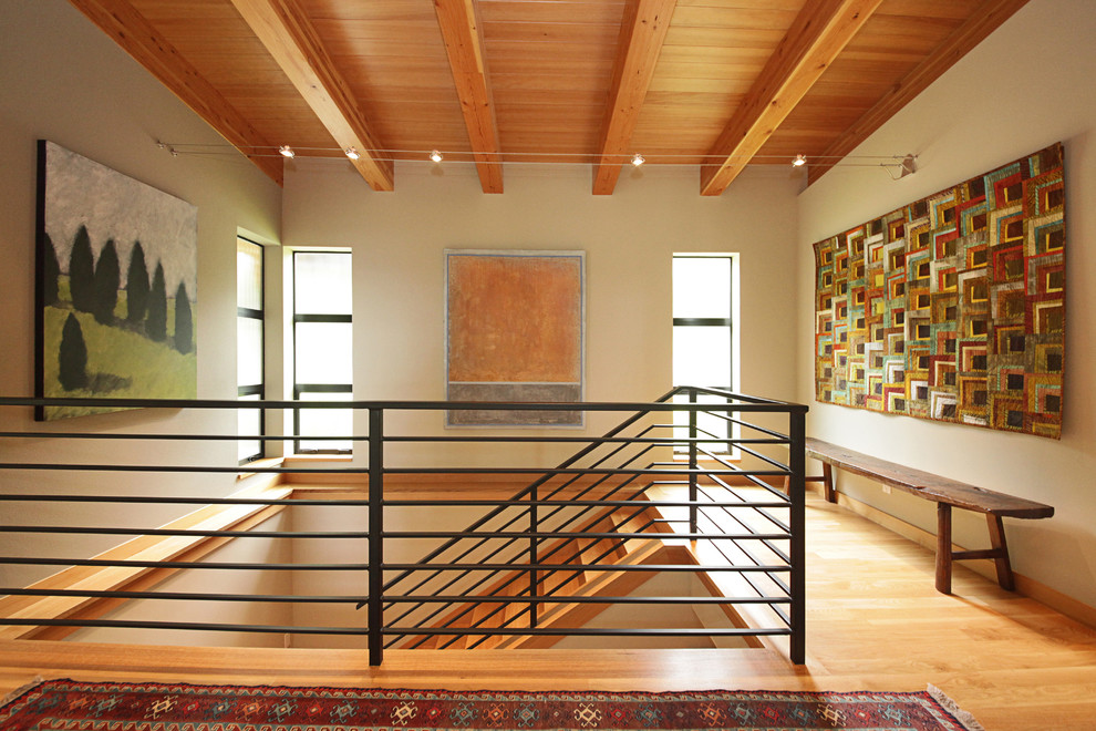 Ejemplo de escalera recta contemporánea grande con escalones de madera, contrahuellas de madera y barandilla de metal