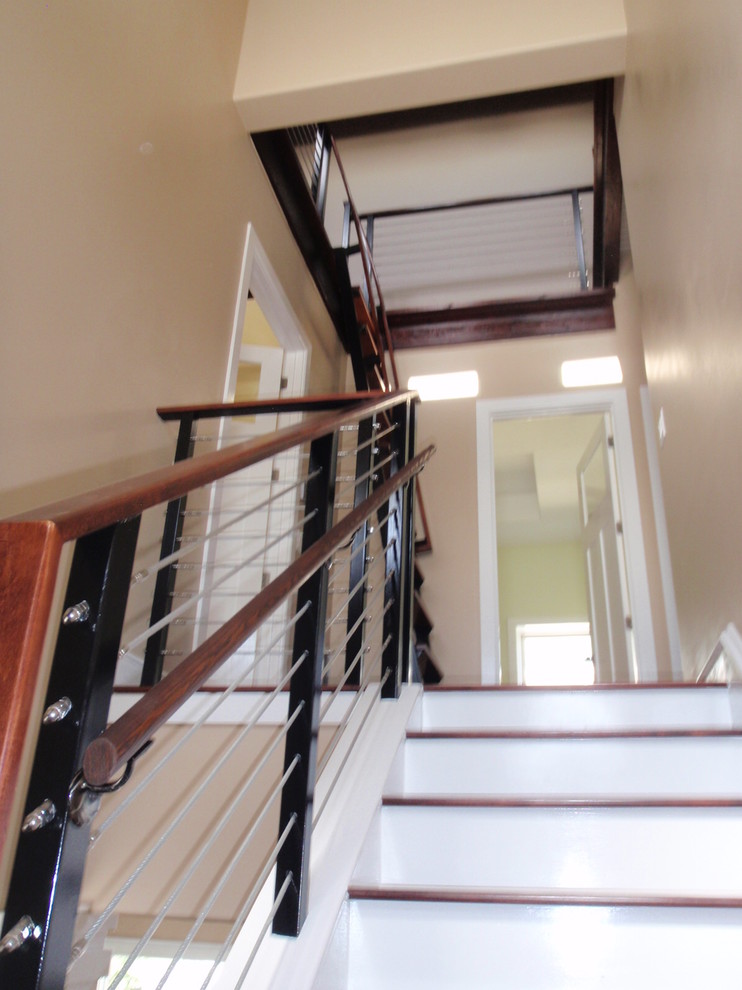 Photo of a medium sized contemporary wood l-shaped wire cable railing staircase in Austin with painted wood risers.