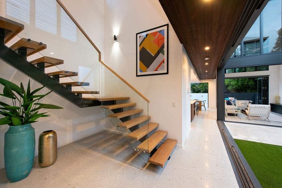 Cette photo montre un escalier courbe tendance de taille moyenne avec des marches en bois, des contremarches en verre et un garde-corps en bois.