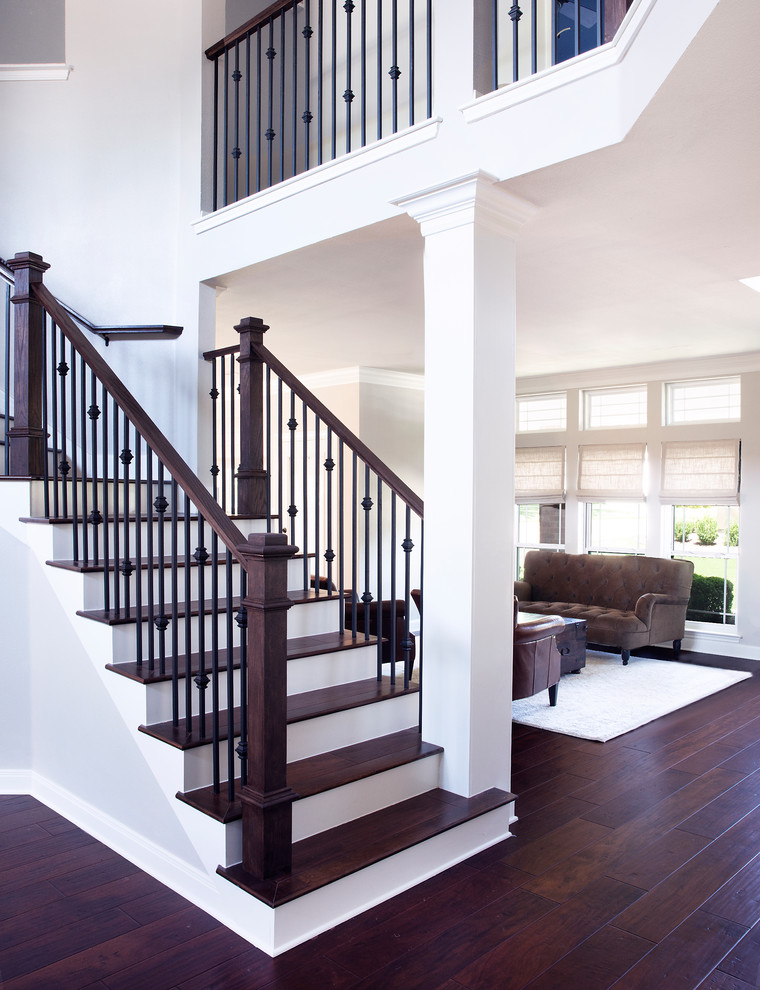 Пример оригинального дизайна: изогнутая лестница среднего размера в стиле неоклассика (современная классика) с деревянными ступенями, крашенными деревянными подступенками и перилами из смешанных материалов