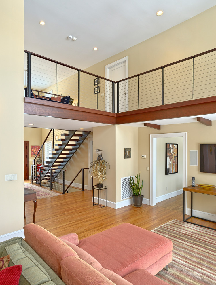 Trendy wooden straight open and cable railing staircase photo in New York