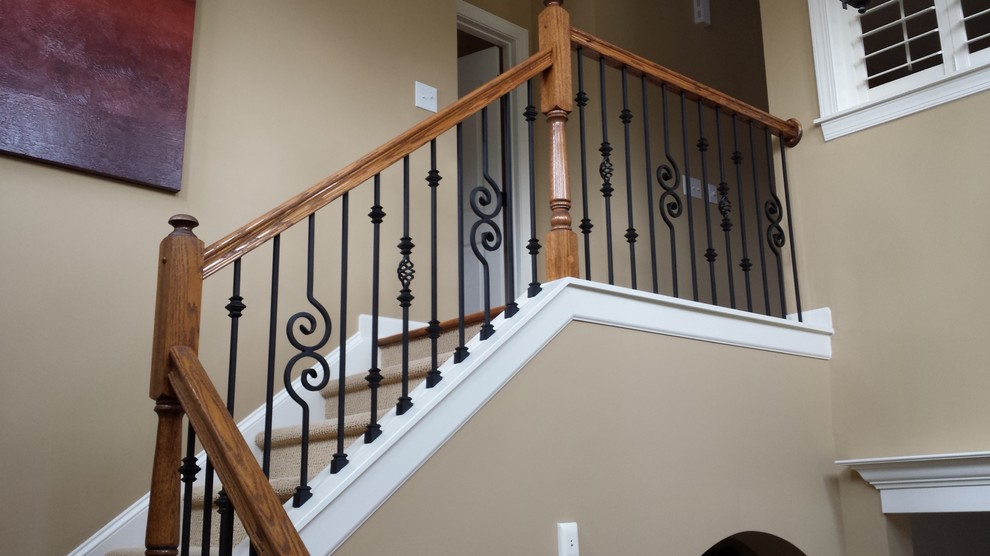 This is an example of a large mediterranean wood curved staircase in Charlotte with painted wood risers.