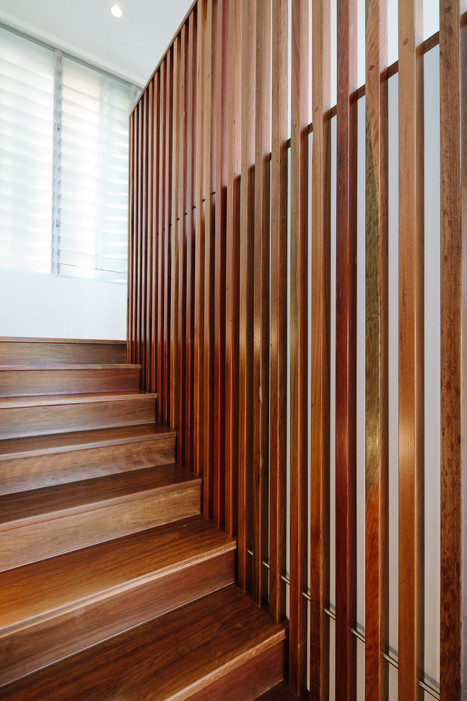 Idée de décoration pour un escalier droit minimaliste de taille moyenne avec des marches en bois, des contremarches en bois et un garde-corps en bois.