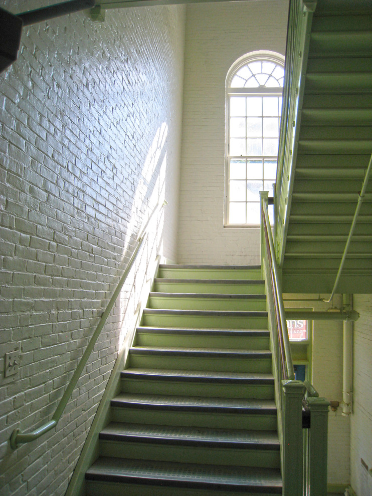 Aménagement d'un grand escalier classique en U avec des contremarches en métal.