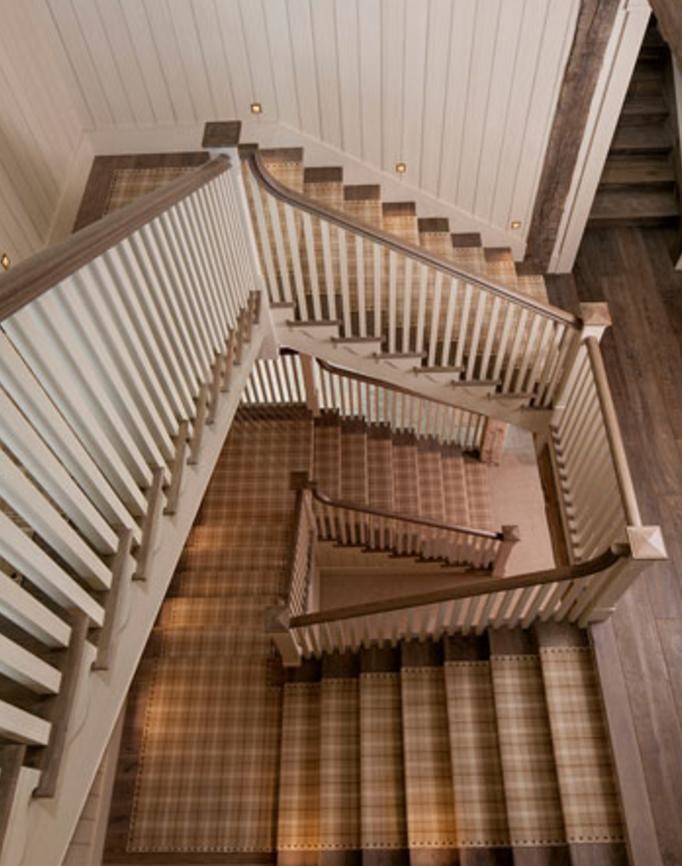 Ejemplo de escalera en L campestre grande con escalones de madera, contrahuellas de madera y barandilla de madera