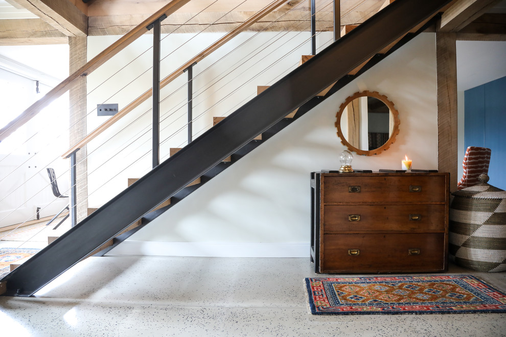 Ejemplo de escalera recta de estilo de casa de campo grande sin contrahuella con escalones de madera y barandilla de metal