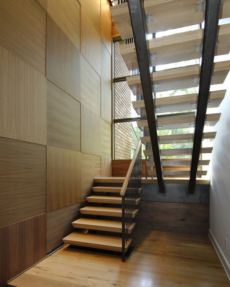 This is an example of a large contemporary wood u-shaped staircase in New York with open risers.