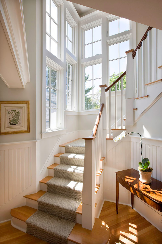 Example of a large ornate wooden curved staircase design in Boston with painted risers