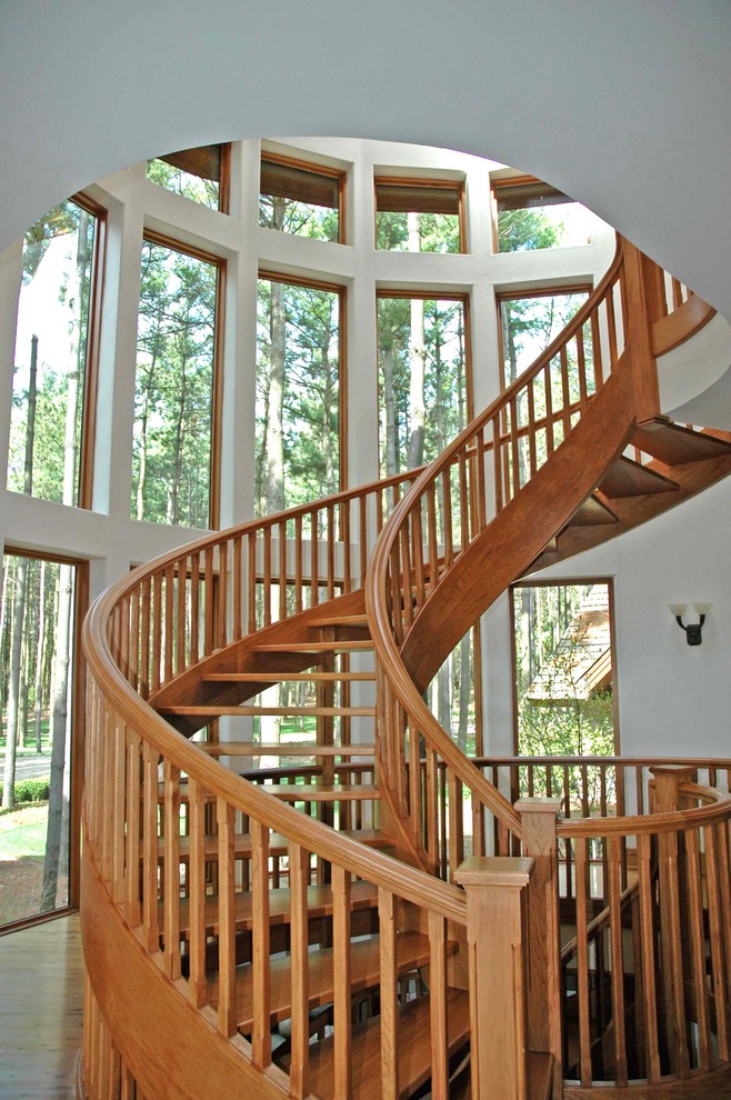 Huge mountain style wooden curved open staircase photo in Chicago