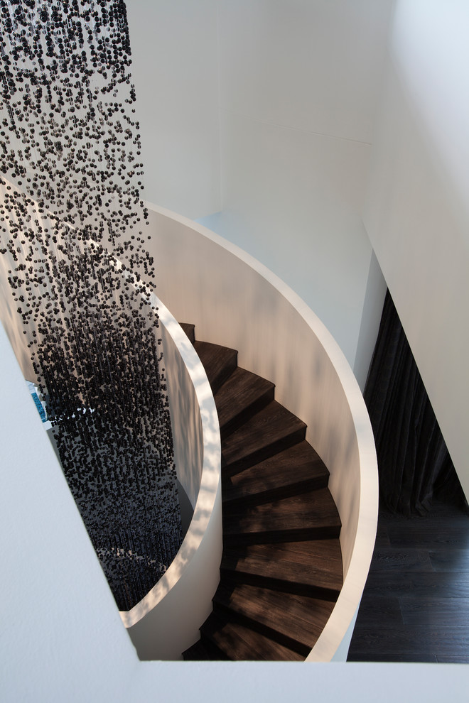 Idée de décoration pour un escalier courbe design avec des marches en bois et des contremarches en bois.