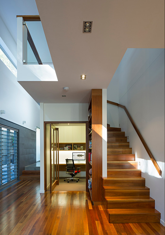 Imagen de escalera curva actual con escalones de madera y contrahuellas de madera