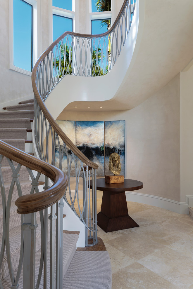 Huge transitional carpeted curved metal railing staircase photo in Other with wooden risers