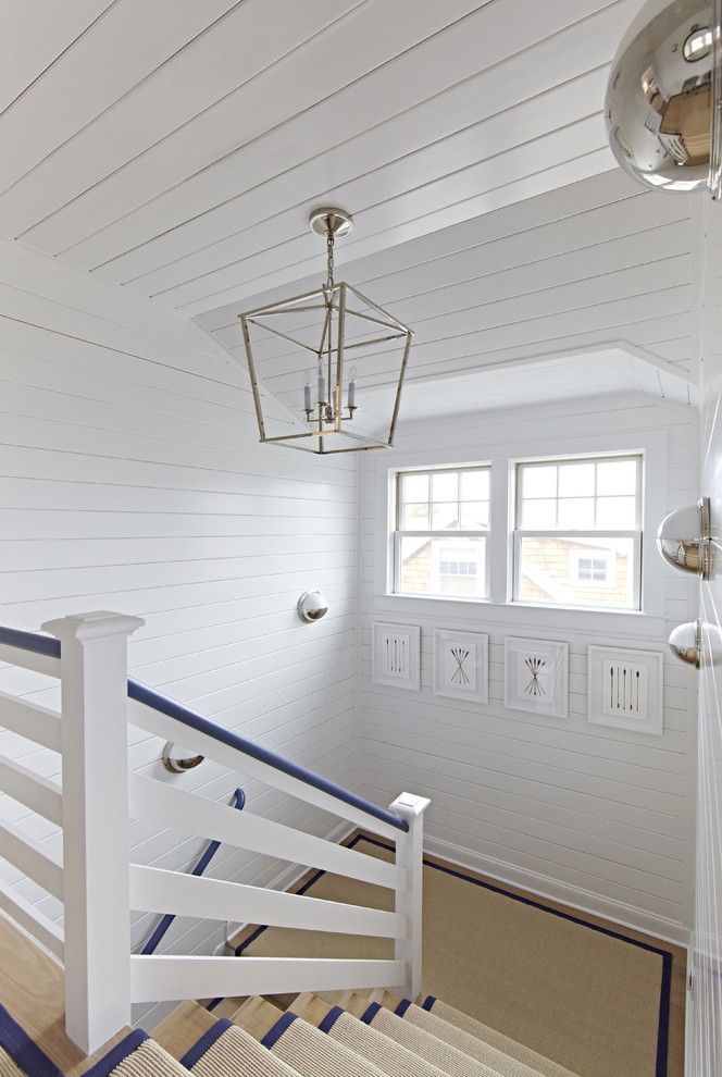 Design ideas for a medium sized nautical wood u-shaped staircase in New York with painted wood risers.