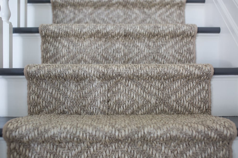 This is an example of a beach style carpeted l-shaped staircase in New York with carpeted risers.